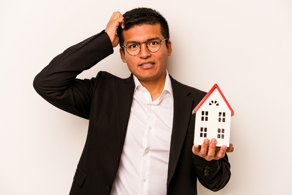confused real estate investor, holding model house