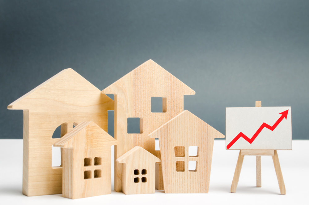 wooden model houses, red arrow, rising rates
